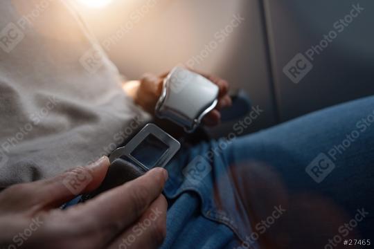 Airplane passenger hands fastening a seat belt, backlit by window light. safe flight on airplane concept image  : Stock Photo or Stock Video Download rcfotostock photos, images and assets rcfotostock | RC Photo Stock.: