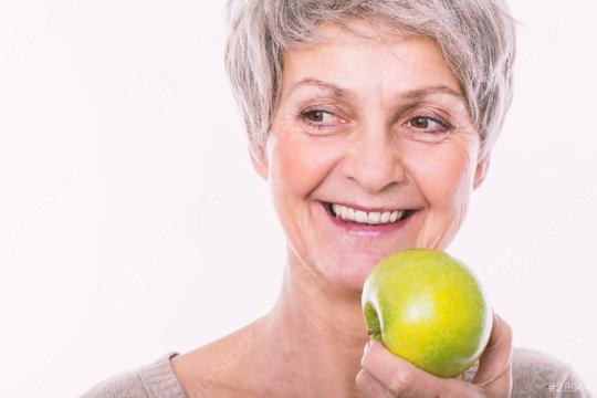 An older woman with short gray hair smiles while holding a green apple against a plain white background.  : Stock Photo or Stock Video Download rcfotostock photos, images and assets rcfotostock | RC Photo Stock.: