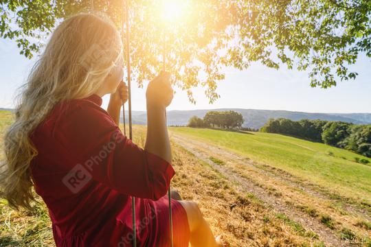 Back view of happy blond girl on swing in sun light  : Stock Photo or Stock Video Download rcfotostock photos, images and assets rcfotostock | RC Photo Stock.: