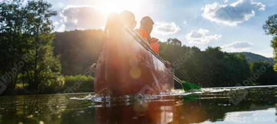 Back view of three people in a canoe paddling on a river, highlighted by warm sunlight and lens flare at a river in germany. Family on kayak ride. Wild nature and water fun on summer vacation.  : Stock Photo or Stock Video Download rcfotostock photos, images and assets rcfotostock | RC Photo Stock.: