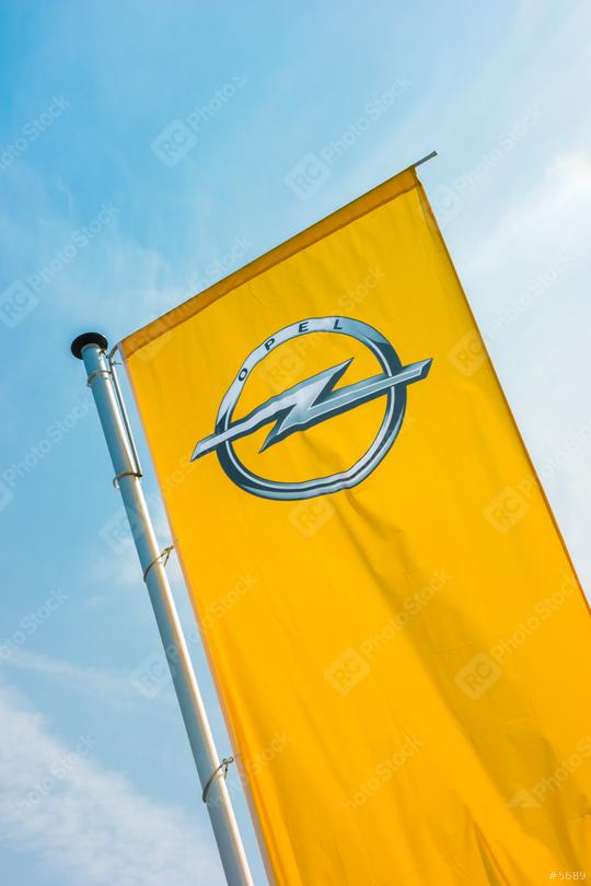BAESWEILER, GERMANY MARCH, 2017: Opel flag closeup against blue sky at the Opel Store. Opel AG is a German automobile manufacturer.  : Stock Photo or Stock Video Download rcfotostock photos, images and assets rcfotostock | RC Photo Stock.:
