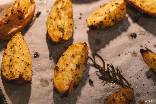 Baked potato wedges with rosemary on baking paper -  homemade organic vegetable vegan vegetarian potato wedges snack food meal.  : Stock Photo or Stock Video Download rcfotostock photos, images and assets rcfotostock | RC Photo Stock.: