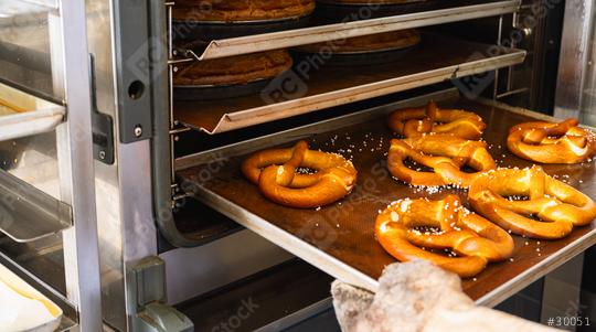 Baker getting fresh bavarian pretzels out of oven on baking sheet from the bakery  : Stock Photo or Stock Video Download rcfotostock photos, images and assets rcfotostock | RC Photo Stock.: