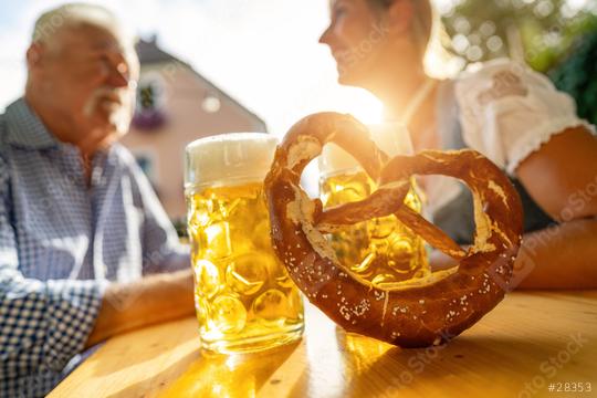 Bavarian Beer mugs and pretzel on table with senior man and woman in the background at beer garden, Munich, Germany  : Stock Photo or Stock Video Download rcfotostock photos, images and assets rcfotostock | RC Photo Stock.: