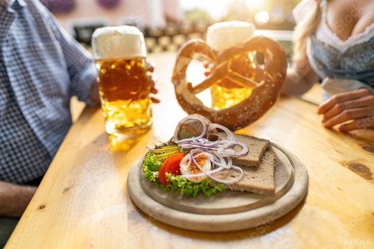 Bavarian Obatzda with pretzels and radishes and beer mugs, man and young woman in tracht in the background at beer garden or oktoberfest, Munich, Germany  : Stock Photo or Stock Video Download rcfotostock photos, images and assets rcfotostock | RC Photo Stock.: