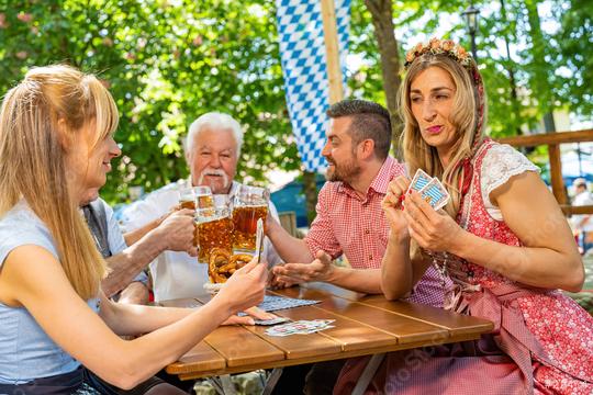 Bavarian people in traditional costume playing traditional card game of Schafkopf in a German beer garden or oktoberfest  : Stock Photo or Stock Video Download rcfotostock photos, images and assets rcfotostock | RC Photo Stock.: