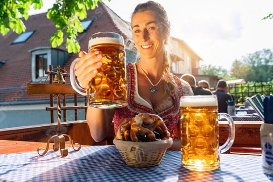 Bavarian woman with beer and pretzel in beautiful Beer garden or oktoberfest at a sunny day  : Stock Photo or Stock Video Download rcfotostock photos, images and assets rcfotostock | RC Photo Stock.: