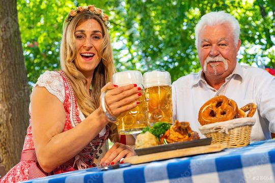 Bavarian women and old man clinking beer mugs with traditional Bavarian cuisine with roasted ham hock in a beer garden or oktoberfest  : Stock Photo or Stock Video Download rcfotostock photos, images and assets rcfotostock | RC Photo Stock.: