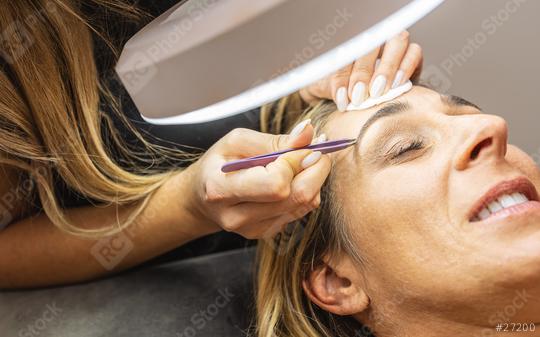 Beautiful woman having her eyebrows plucked by a beautician in a spa or beauty salon in a wellness concept.  : Stock Photo or Stock Video Download rcfotostock photos, images and assets rcfotostock | RC Photo Stock.: