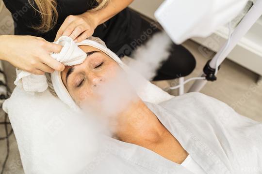 Beauty clinic treatment of blemishes, beautician cosmetologist cleaning moisturizing client skin with skincare vaporizer with mist steam for deep facial cleansing  : Stock Photo or Stock Video Download rcfotostock photos, images and assets rcfotostock | RC Photo Stock.: