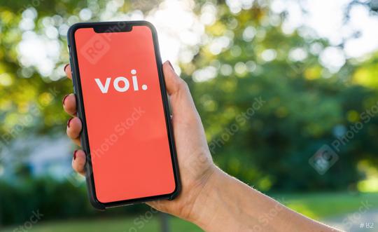 BERLIN, GERMANY AUGUST 2019: Woman hand holding iphone Xs with logo of VOI app displayed on a smartphone to rent a e-Scooter. Voi is a rental electric scooter company. Quick and easy way to travel  : Stock Photo or Stock Video Download rcfotostock photos, images and assets rcfotostock | RC-Photo-Stock.: