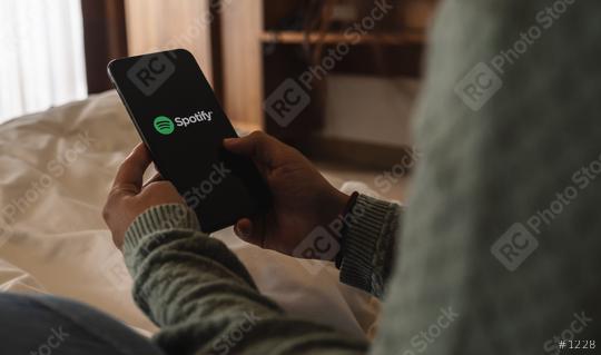 BERLIN, GERMANY AUGUST 2019: Woman holding a iPhone Xs opening spotify app in the bed, Spotify is a music service that offers legal streaming music.  : Stock Photo or Stock Video Download rcfotostock photos, images and assets rcfotostock | RC Photo Stock.: