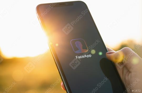 BERLIN, GERMANY JULY 2019: Hand Holding Iphone Xs with FaceApp on the screen, faceapp is a popular photo editing application on the App Store. And edit highly realistic transformations of faces.  : Stock Photo or Stock Video Download rcfotostock photos, images and assets rcfotostock | RC Photo Stock.: