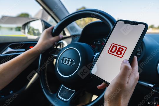 BERLIN, GERMANY JULY 2019: Woman hand holding iphone Xs with Deutsche Bahn logo on screen in a car. Deutsche Bahn (DB) is the main German train company for transporting goods and passengers.  : Stock Photo or Stock Video Download rcfotostock photos, images and assets rcfotostock | RC Photo Stock.: