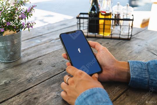 BERLIN, GERMANY JULY 2019: Woman hand holding iphone Xs with logo of Facebook application in a Restaurant. Facebook is an online social networking service founded in February 2004 by Mark Zuckerberg.  : Stock Photo or Stock Video Download rcfotostock photos, images and assets rcfotostock | RC Photo Stock.:
