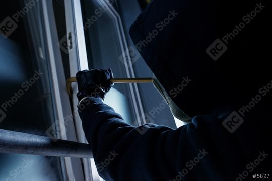 burglar using crowbar to break into a victim
