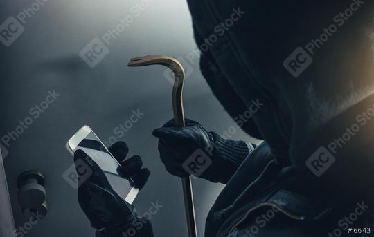 burglar with crowbar and smartphone preparing burglary via smart home app  : Stock Photo or Stock Video Download rcfotostock photos, images and assets rcfotostock | RC Photo Stock.: