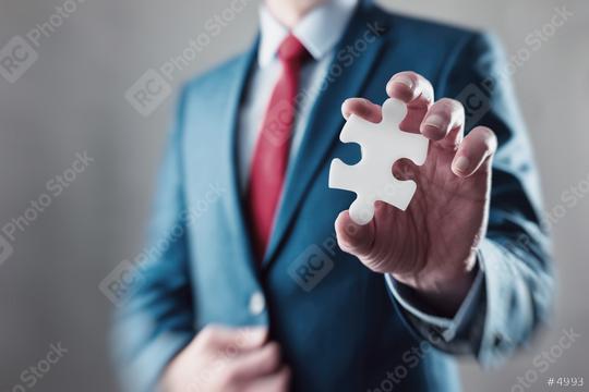 Businessman holding a puzzle to connect   : Stock Photo or Stock Video Download rcfotostock photos, images and assets rcfotostock | RC Photo Stock.: