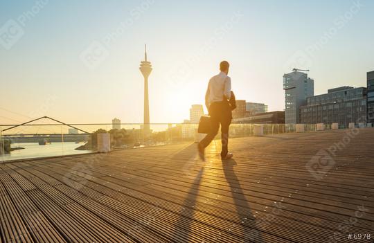 Businessman walking on a bridge at sunrise in dusseldorf  : Stock Photo or Stock Video Download rcfotostock photos, images and assets rcfotostock | RC Photo Stock.: