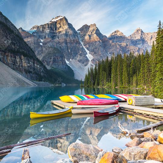 Canoes on a jetty at  Moraine lake in Banff National Park, Alberta, Canada, with snow-covered peaks of canadian Rocky Mountains in the background  : Stock Photo or Stock Video Download rcfotostock photos, images and assets rcfotostock | RC Photo Stock.: