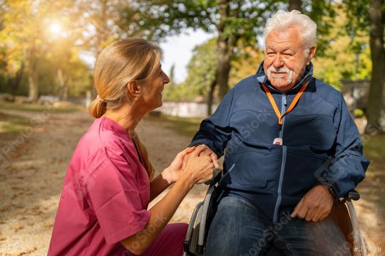 caregiver in pink kneels beside a smiling elderly man in a wheelchair in a sunny autumn park. Dementia retirement home concept image  : Stock Photo or Stock Video Download rcfotostock photos, images and assets rcfotostock | RC Photo Stock.: