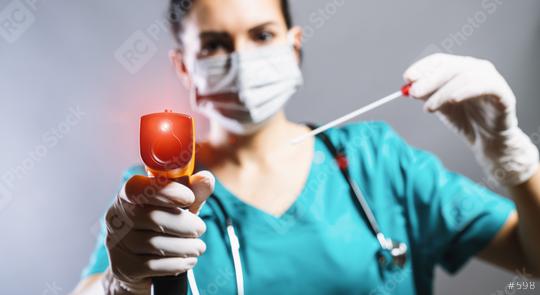 Checking the temperature with a laser thermometer by a person in a protective suit, protective mask and smear tube test. Thermometer (thermometer gun) held in hands wearing disposable gloves.  : Stock Photo or Stock Video Download rcfotostock photos, images and assets rcfotostock | RC Photo Stock.: