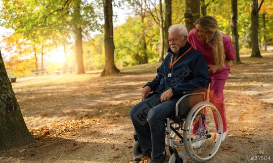 Cheerful elderly man in a wheelchair with a nurse in a park, wearing a SOS button, autumn setting  : Stock Photo or Stock Video Download rcfotostock photos, images and assets rcfotostock | RC Photo Stock.: