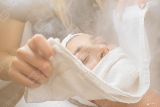 Close up of a woman with eyes closed having thermal steam treatment on face with towel at a cosmetology salon or spa.   : Stock Photo or Stock Video Download rcfotostock photos, images and assets rcfotostock | RC Photo Stock.: