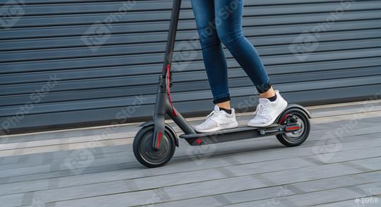 Close up of woman riding black electric kick scooter at cityscape, motion blur  : Stock Photo or Stock Video Download rcfotostock photos, images and assets rcfotostock | RC Photo Stock.: