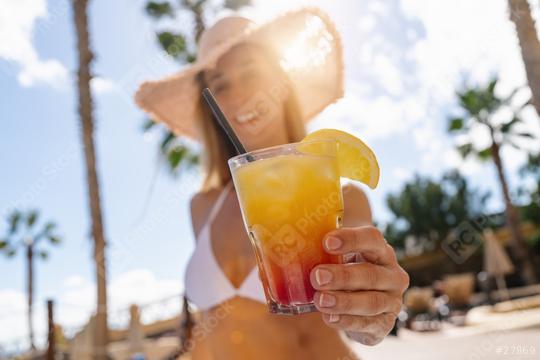 Close-up of a colorful cocktail held by a woman in a bikini, with a straw hat and palm trees at a caribbean island hotel  : Stock Photo or Stock Video Download rcfotostock photos, images and assets rcfotostock | RC Photo Stock.: