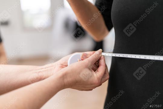 Close-up of a fitness trainer measuring a woman