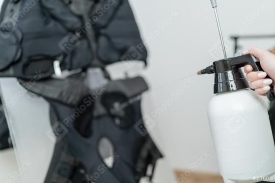 Close-up of a hand operating with a spray bottle to preparing ems vest in a EMS - Studio  : Stock Photo or Stock Video Download rcfotostock photos, images and assets rcfotostock | RC Photo Stock.: