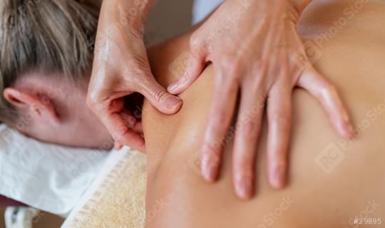 Close-up of a massage therapist applying pressure on a client