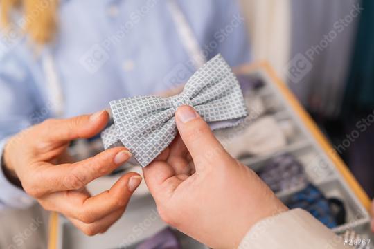 Close-up of hands holding a light blue patterned bow tie in a tailor shop  : Stock Photo or Stock Video Download rcfotostock photos, images and assets rcfotostock | RC Photo Stock.: