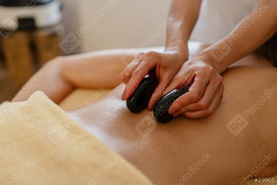 Close-up of hot stone massage therapy on a bare back with therapist’s hands at a beauty salon or hotel  : Stock Photo or Stock Video Download rcfotostock photos, images and assets rcfotostock | RC Photo Stock.: