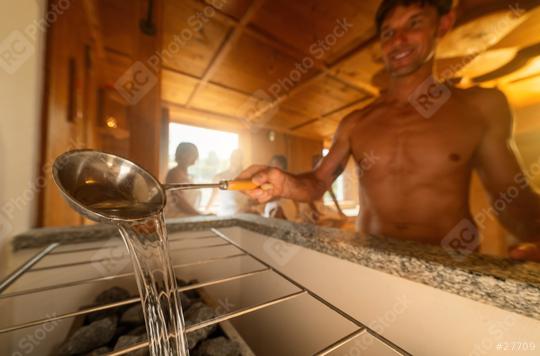 Close-up of man with ladle pouring water on hot sauna stones, with a blurred person in the background. Finish sauna spa wellness hotel concept image  : Stock Photo or Stock Video Download rcfotostock photos, images and assets rcfotostock | RC Photo Stock.: