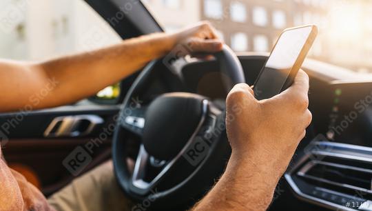 Close-up of young man holding mobile phone in his hand he using navigator during driving  : Stock Photo or Stock Video Download rcfotostock photos, images and assets rcfotostock | RC Photo Stock.: