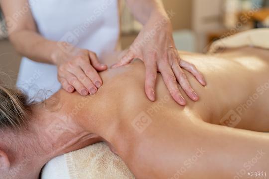 Close-up view of a massage therapist applying pressure to a female client