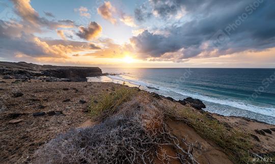 Coastal landscape at sunset with rocky shoreline and waves, under a dramatic sky at Playa de Cofete, Fuerteventura, Canary Islands.  : Stock Photo or Stock Video Download rcfotostock photos, images and assets rcfotostock | RC Photo Stock.: