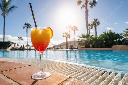 Colorful tropical cocktail on a poolside ledge with a backdrop of palm trees and a bright sunny sky at spanish hotel  : Stock Photo or Stock Video Download rcfotostock photos, images and assets rcfotostock | RC Photo Stock.: