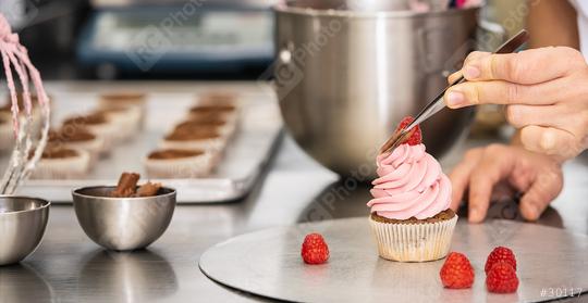 confectioner hand draped pieces of chocolate on a muffin topping with tweezers in a pastry bakery   : Stock Photo or Stock Video Download rcfotostock photos, images and assets rcfotostock | RC Photo Stock.:
