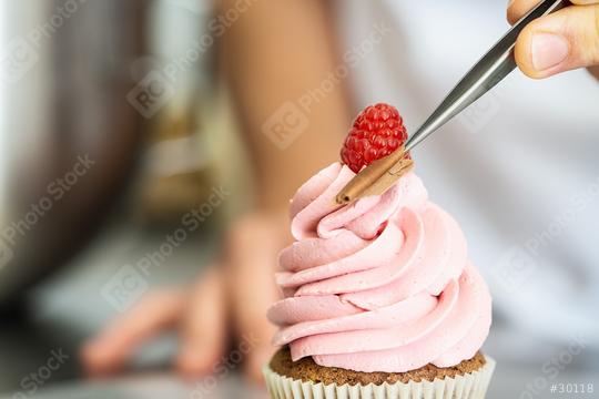 confectioner hand draped pieces of chocolate on a muffin topping with tweezers in a pastry bakery   : Stock Photo or Stock Video Download rcfotostock photos, images and assets rcfotostock | RC Photo Stock.:
