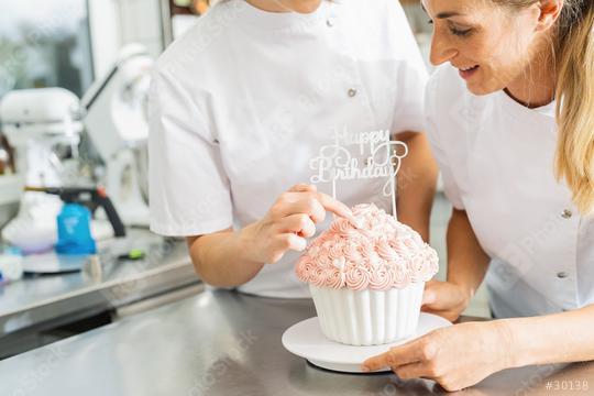 confectioners decorating big Birthday cake muffin with candies at pastry bakery  : Stock Photo or Stock Video Download rcfotostock photos, images and assets rcfotostock | RC Photo Stock.: