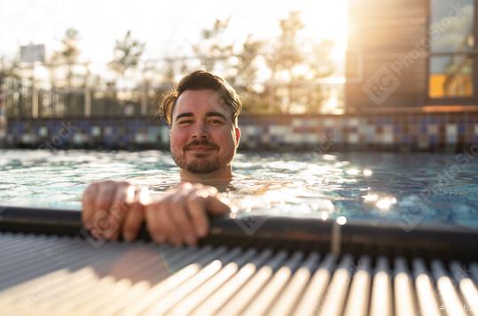 Content man leaning on the edge of a pool in a hotel, sunlight s  : Stock Photo or Stock Video Download rcfotostock photos, images and assets rcfotostock | RC Photo Stock.: