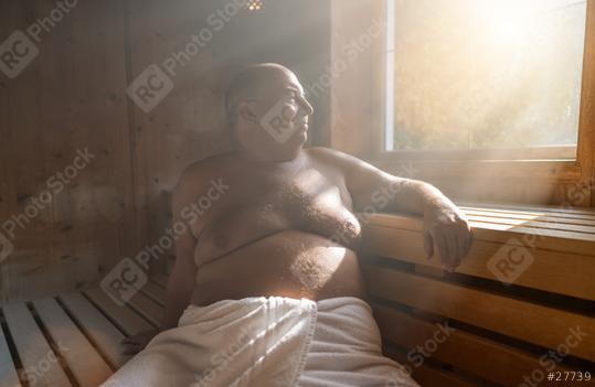 Content man relaxing in a finnish sauna, with sunlight streaming through the window.  : Stock Photo or Stock Video Download rcfotostock photos, images and assets rcfotostock | RC Photo Stock.: