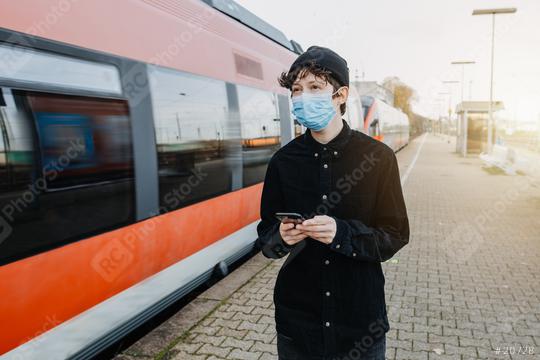 Coronavirus, COVID-19. Young german man with medical face mask to protect against the coronavirus while waiting for the train on the subway platform. Mouth protection obligation at the train station  : Stock Photo or Stock Video Download rcfotostock photos, images and assets rcfotostock | RC Photo Stock.: