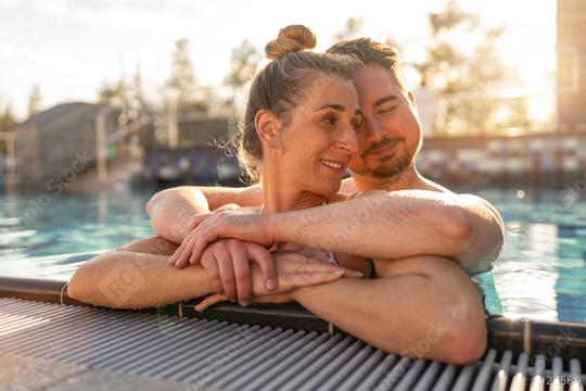 Couple embracing in a pool at sunset, woman smiling and leaning   : Stock Photo or Stock Video Download rcfotostock photos, images and assets rcfotostock | RC Photo Stock.: