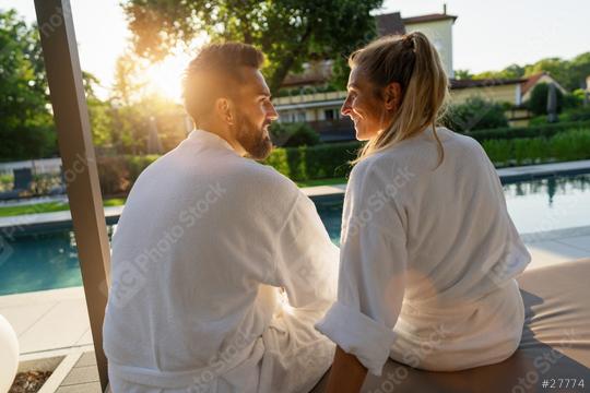 Couple in love looking to each other white bathrobes enjoying sunset by a pool in a spa wellness hotel  : Stock Photo or Stock Video Download rcfotostock photos, images and assets rcfotostock | RC Photo Stock.: