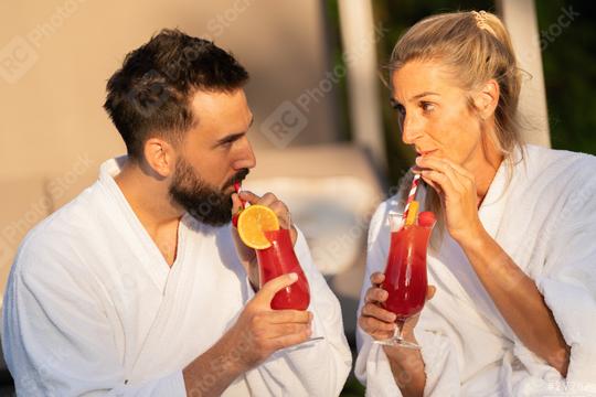 couple in white bathrobes drinking cocktails and looking at each other at a hotel  : Stock Photo or Stock Video Download rcfotostock photos, images and assets rcfotostock | RC Photo Stock.: