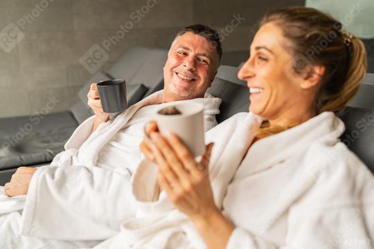 Couple in white robes laughing and holding mugs, reclining in a spa setting  : Stock Photo or Stock Video Download rcfotostock photos, images and assets rcfotostock | RC Photo Stock.: